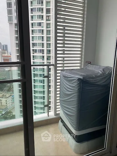 Modern high-rise balcony with city view and covered appliance