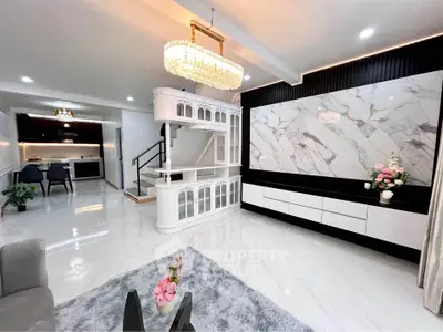 Luxurious living room with elegant chandelier and marble accent wall