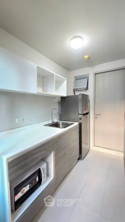 Modern kitchen with sleek cabinetry and stainless steel appliances in a compact layout.