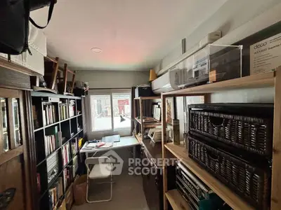 Cozy study room with bookshelves and a window view, perfect for reading and working from home.