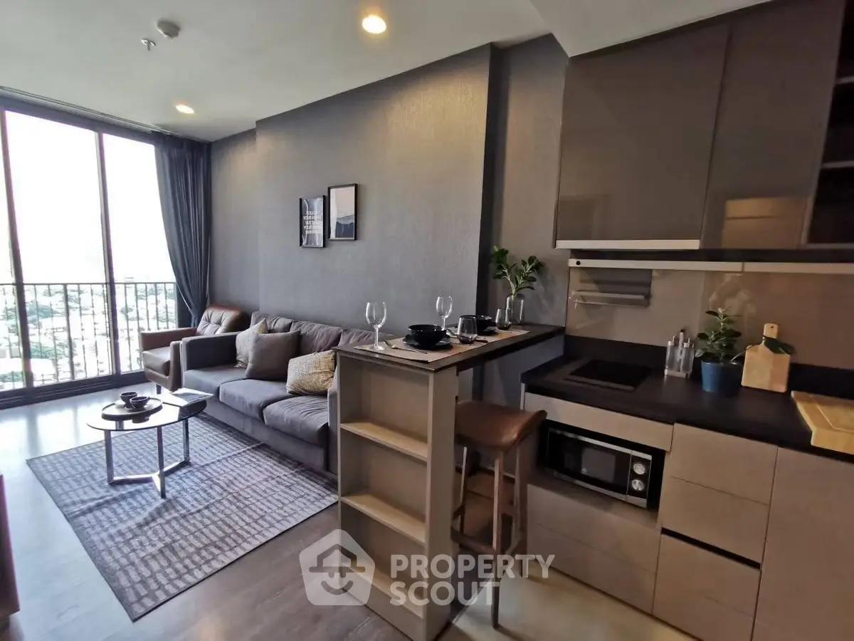 Modern living room with open kitchen and stylish decor in a high-rise apartment.