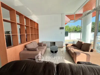 Spacious living room with modern furniture and large windows offering natural light.