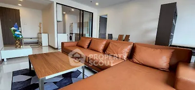 Spacious modern living room with brown leather sofa and stylish decor