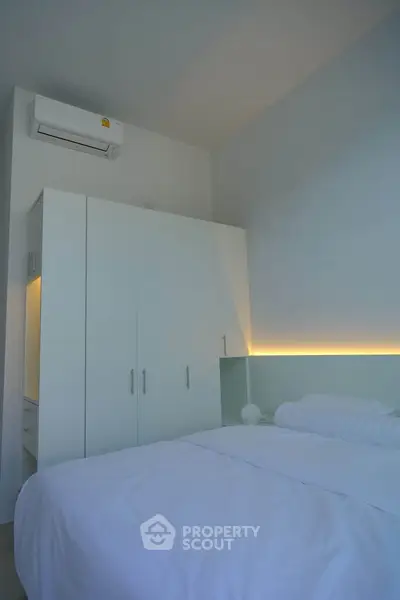 Modern bedroom with sleek white wardrobe and ambient lighting