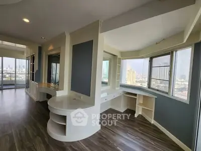 Spacious modern living area with panoramic city views and elegant wood flooring.