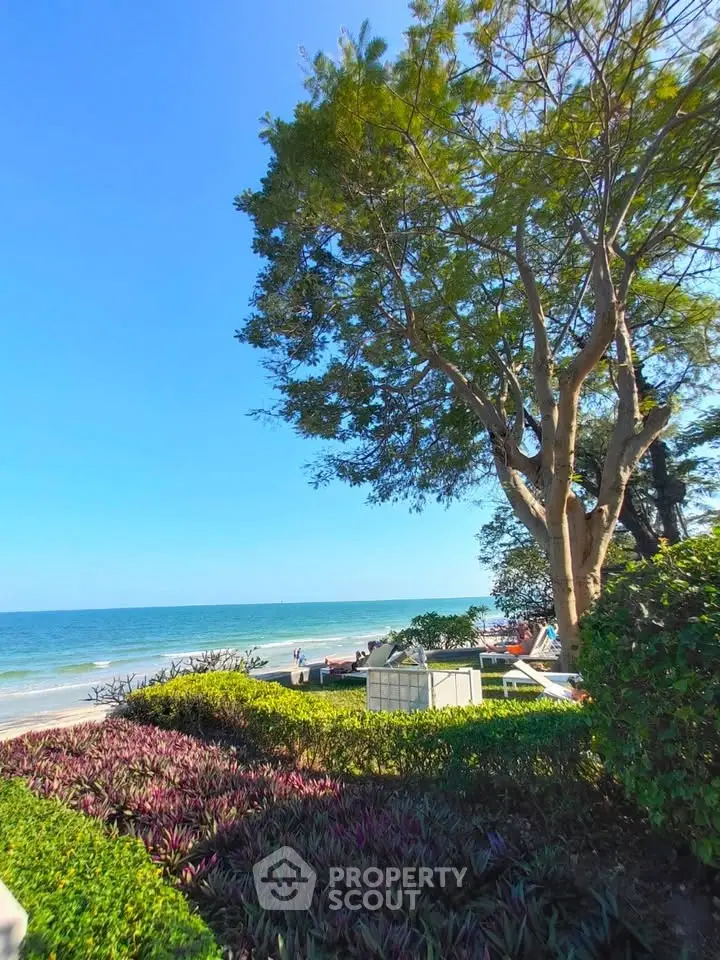 Stunning beachfront view with lush greenery and serene ocean backdrop.