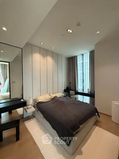 Modern bedroom with cozy bed, large window, and stylish decor in a contemporary apartment.