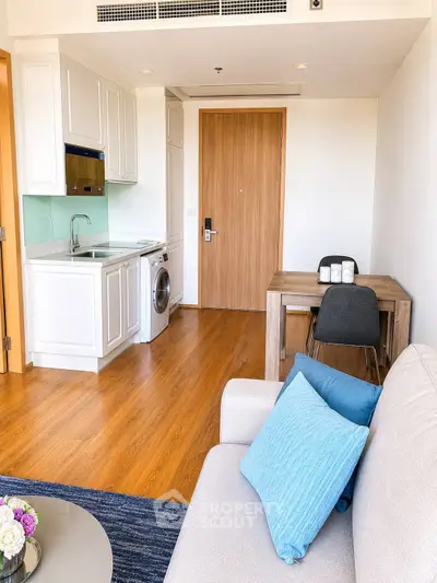 Modern living room with compact kitchen and washing machine in stylish apartment