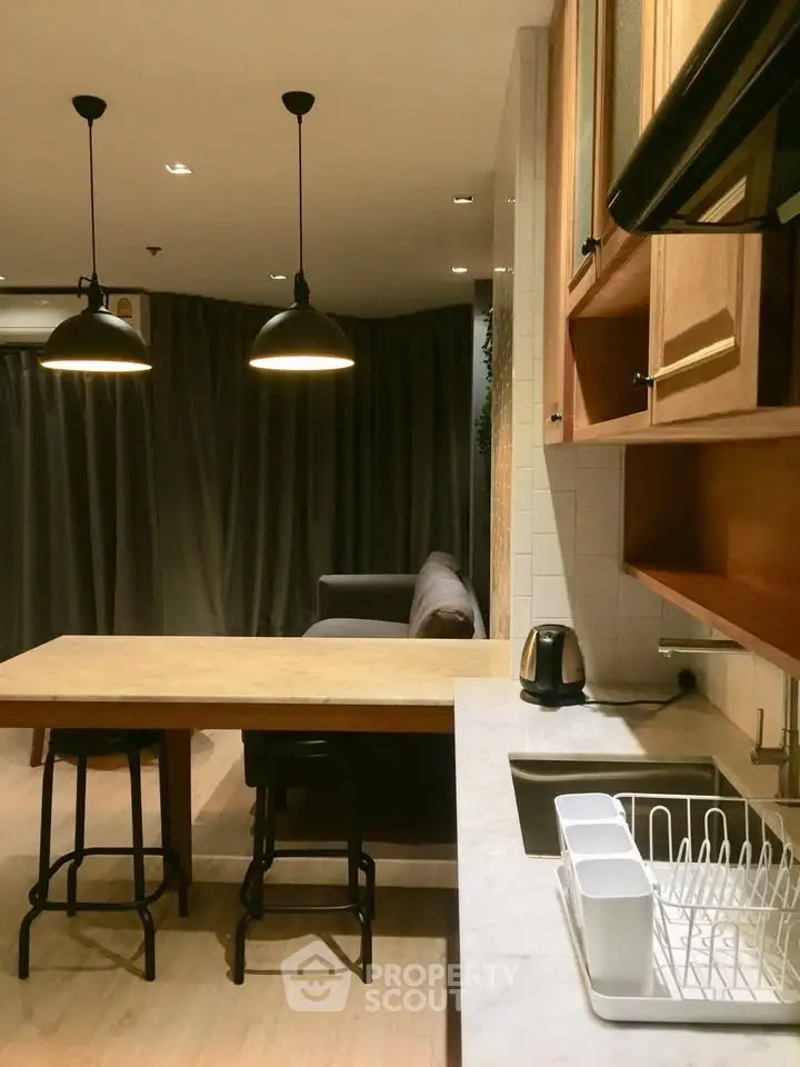 Modern kitchen with open layout and stylish lighting in a cozy apartment.