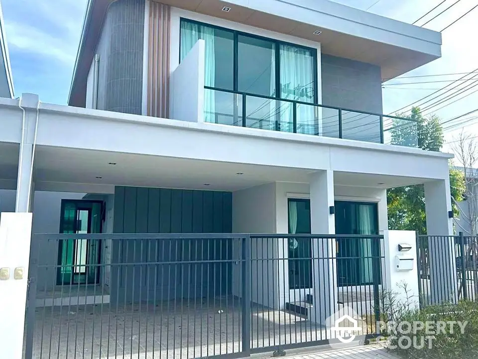 Modern two-story house with sleek design and spacious balcony in a serene neighborhood.