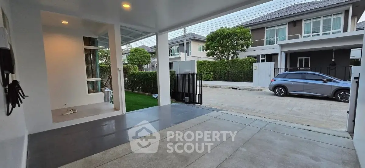 Modern residential entrance with spacious driveway and lush greenery