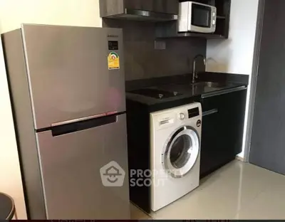 Modern kitchen with stainless steel fridge, washing machine, and microwave