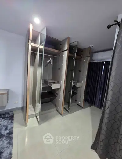 Spacious modern wardrobe with glass doors in a stylish bedroom setting.