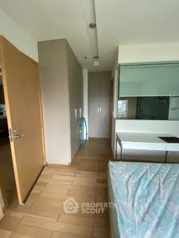 Modern bedroom with wooden flooring and minimalist design in a stylish apartment.