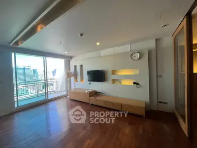 Spacious modern living room with wooden floors and city view balcony