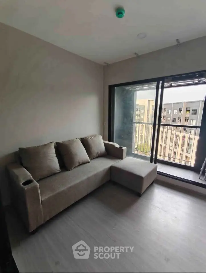 Modern living room with cozy sofa and balcony view in urban apartment