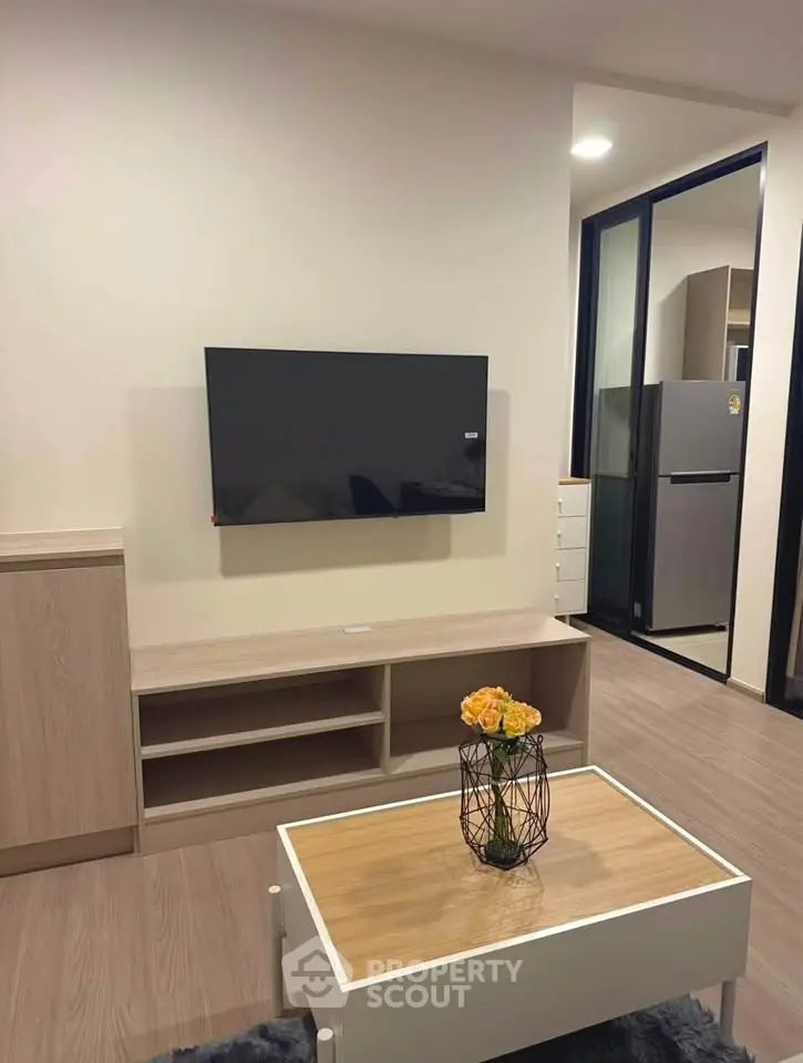 Modern living room with wall-mounted TV and stylish coffee table in a cozy apartment.