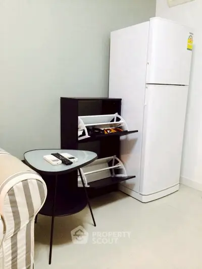 Compact living space with modern furniture and white refrigerator