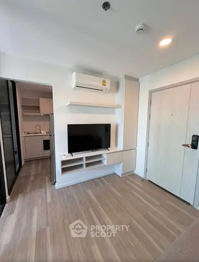 Modern living room with sleek TV setup and air conditioning in a stylish apartment.