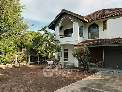 Charming two-story house with lush greenery and spacious outdoor area
