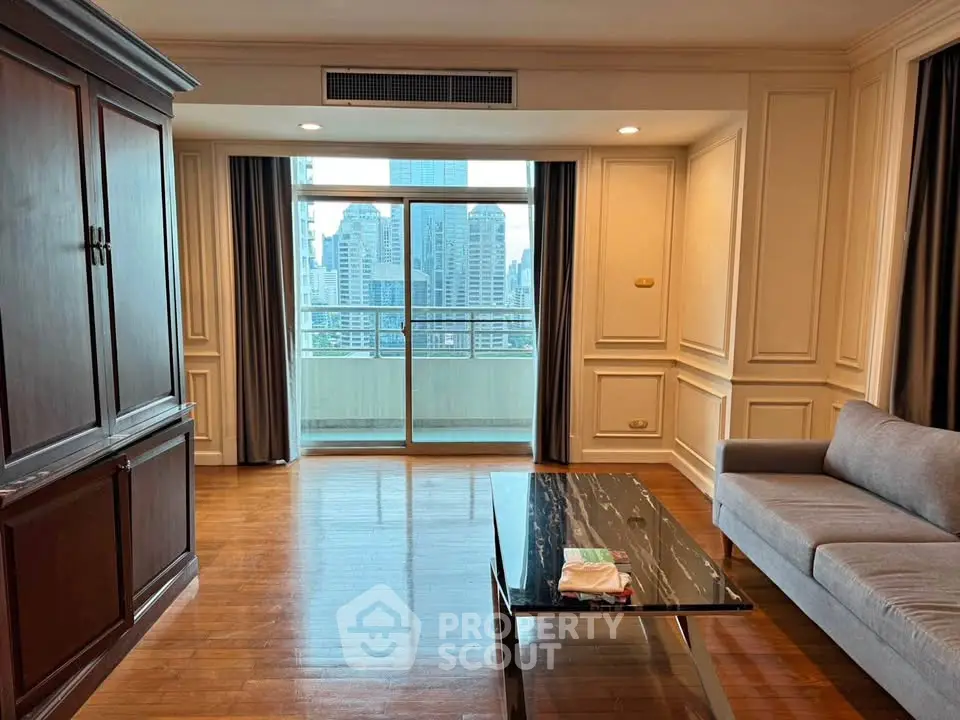 Spacious living room with elegant decor and city view balcony, perfect for urban living.