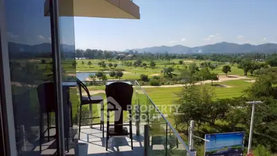 Stunning balcony view overlooking lush golf course and mountains, perfect for relaxation and leisure.