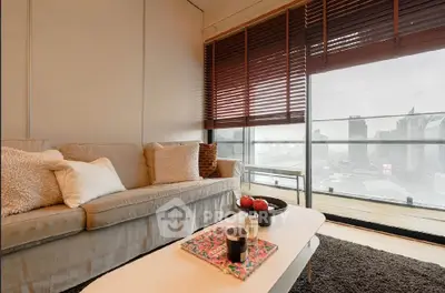Stylish living room with cozy sofa and city view from large windows.