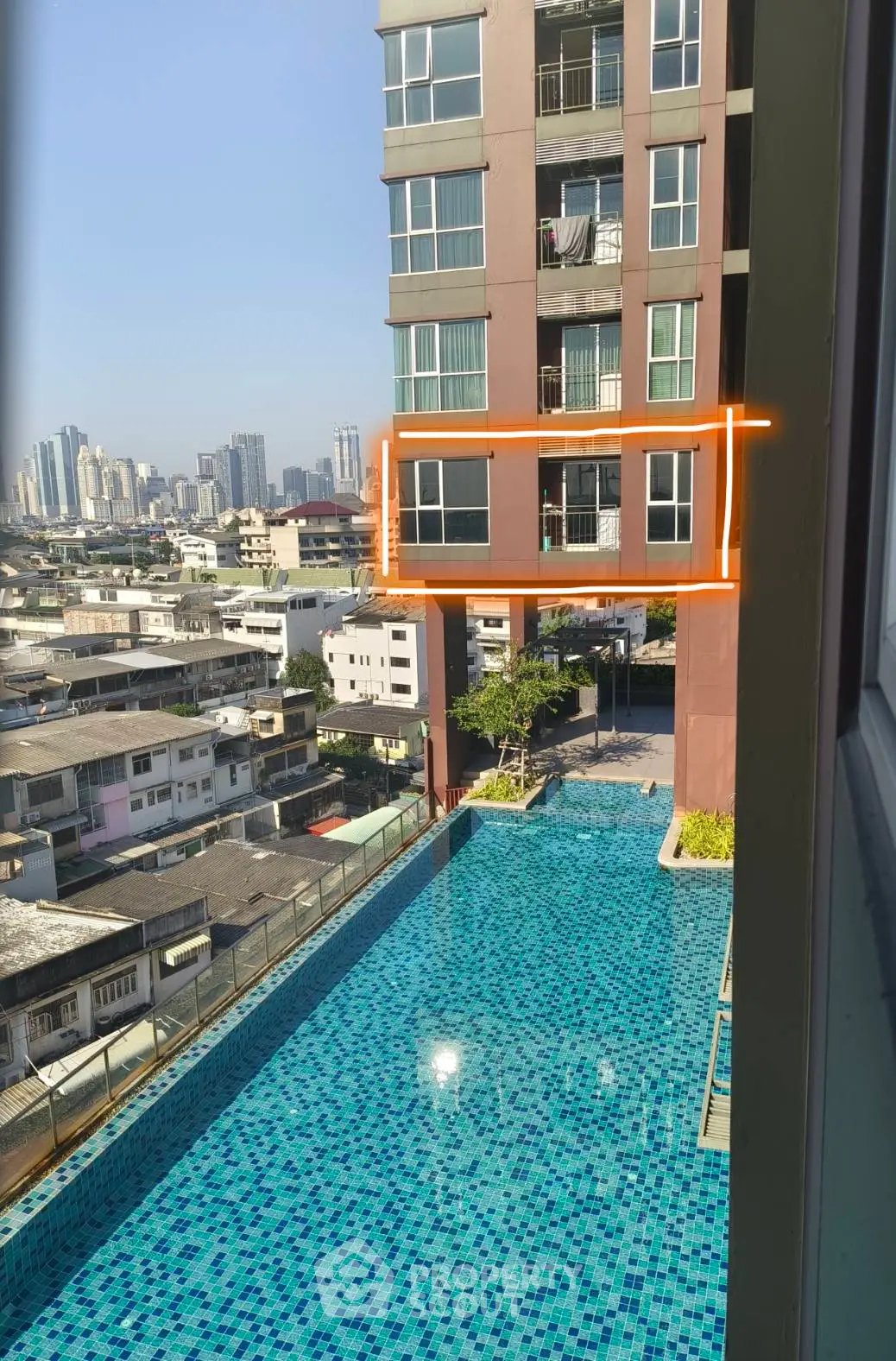 Modern high-rise building with rooftop pool and city view
