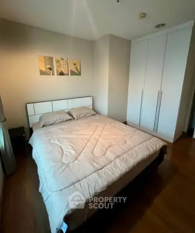 Cozy bedroom with modern decor and spacious wardrobe in a stylish apartment.