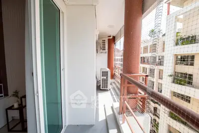Spacious balcony with safety netting and air conditioning unit in modern apartment building.