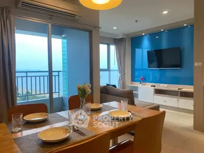 Modern living room with dining area and balcony view in high-rise apartment.