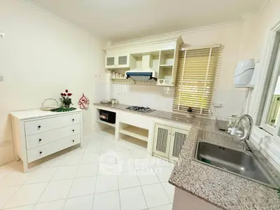 Charming kitchen with granite countertops and gas stove in a cozy home setting.