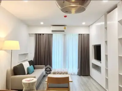 Modern living room with stylish furniture and natural light, perfect for relaxation and entertainment.
