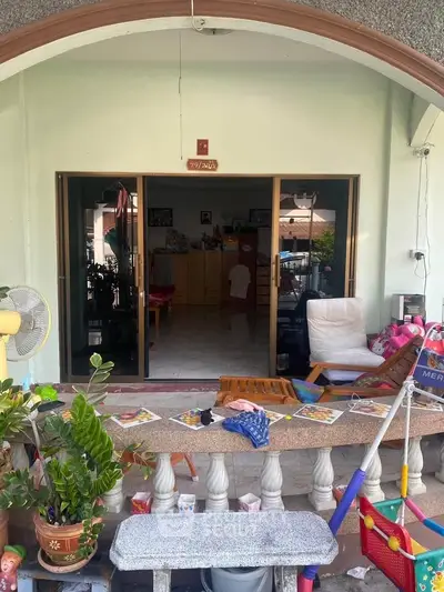 Charming balcony entrance with cozy seating and lush greenery, perfect for relaxation and family gatherings.