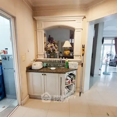 Charming kitchen corner with elegant cabinetry and decorative archway