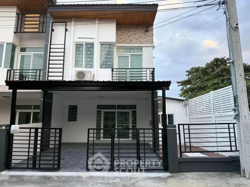 Modern townhouse exterior with sleek black gate and spacious driveway