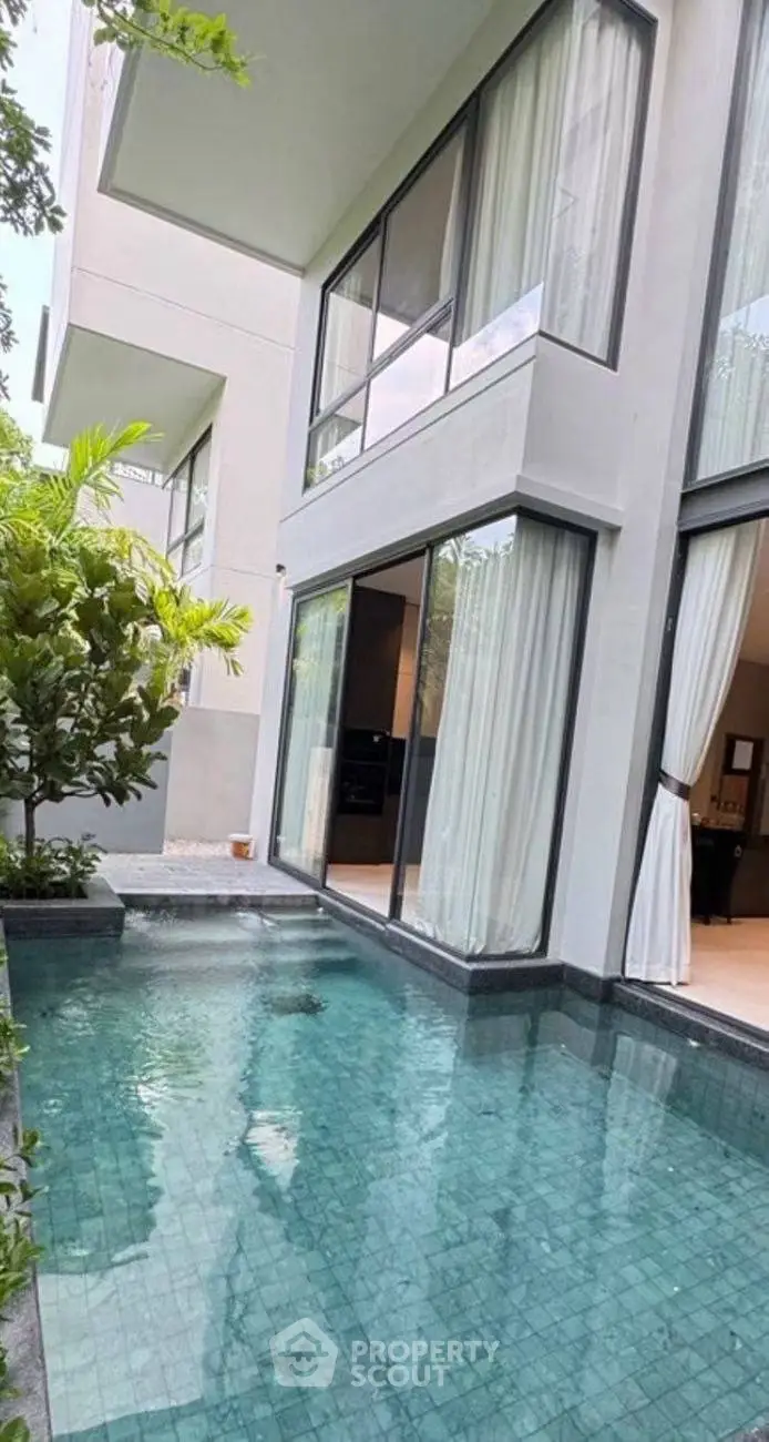 Luxurious modern villa with private pool and floor-to-ceiling windows, perfect for serene living.