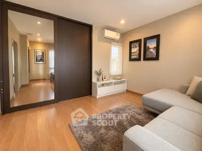 Spacious living room with modern decor and large mirror closet doors.