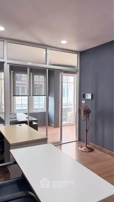 Modern office space with glass partitions and wooden flooring, ideal for productivity and comfort.