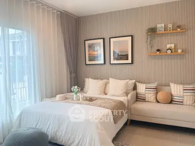 Elegant living room with cozy sofa, stylish decor, and natural light from large window.