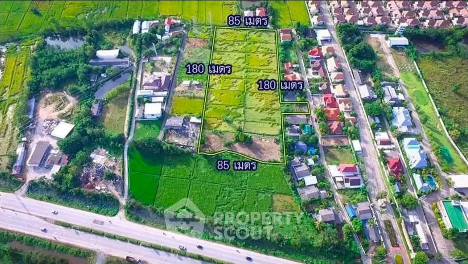 Aerial view of expansive land plots with residential area and road access, ideal for development opportunities.