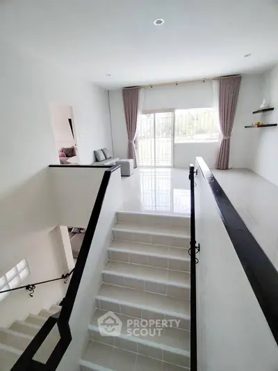 Spacious modern living area with elegant staircase and natural light