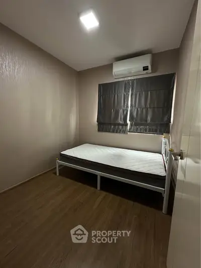 Cozy bedroom with minimalist design and air conditioning, perfect for restful nights.