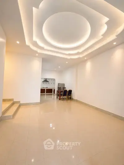 Spacious living room with modern ceiling design and open kitchen layout