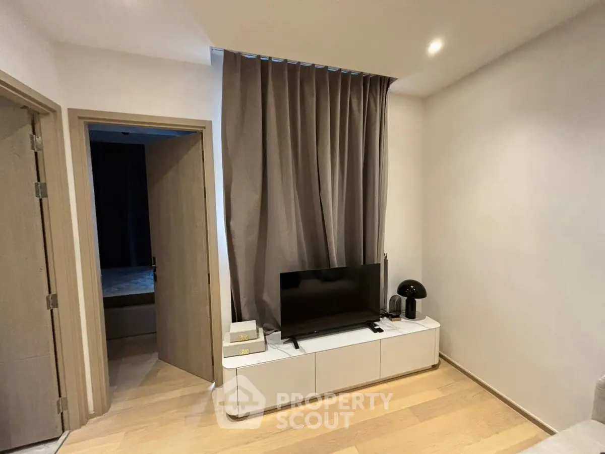 Modern living room with sleek TV stand and elegant curtains, showcasing minimalist design.