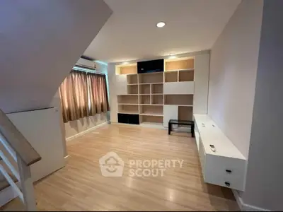 Spacious living room with built-in shelves and natural light, perfect for modern living.