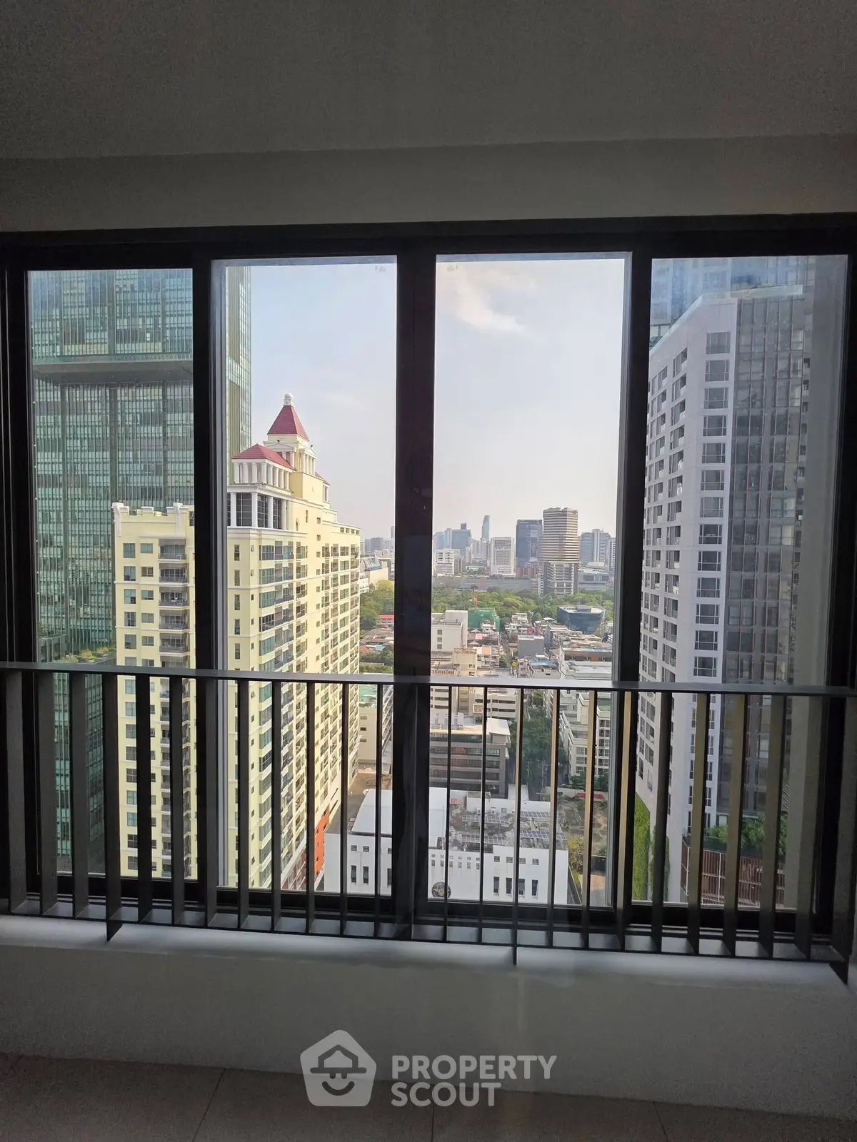 Stunning cityscape view from high-rise apartment window, showcasing urban skyline and modern architecture.