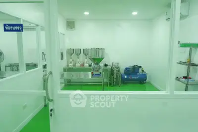 Modern industrial room with green flooring and stainless steel equipment, ideal for manufacturing or laboratory use.