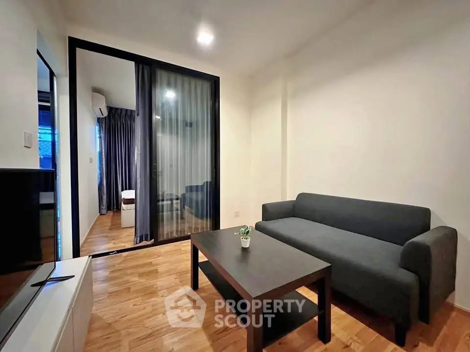 Modern living room with sleek furniture and wooden flooring in a cozy apartment.