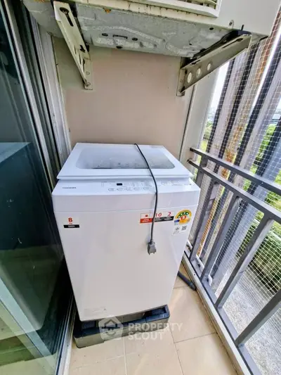 Compact balcony with washing machine and city view